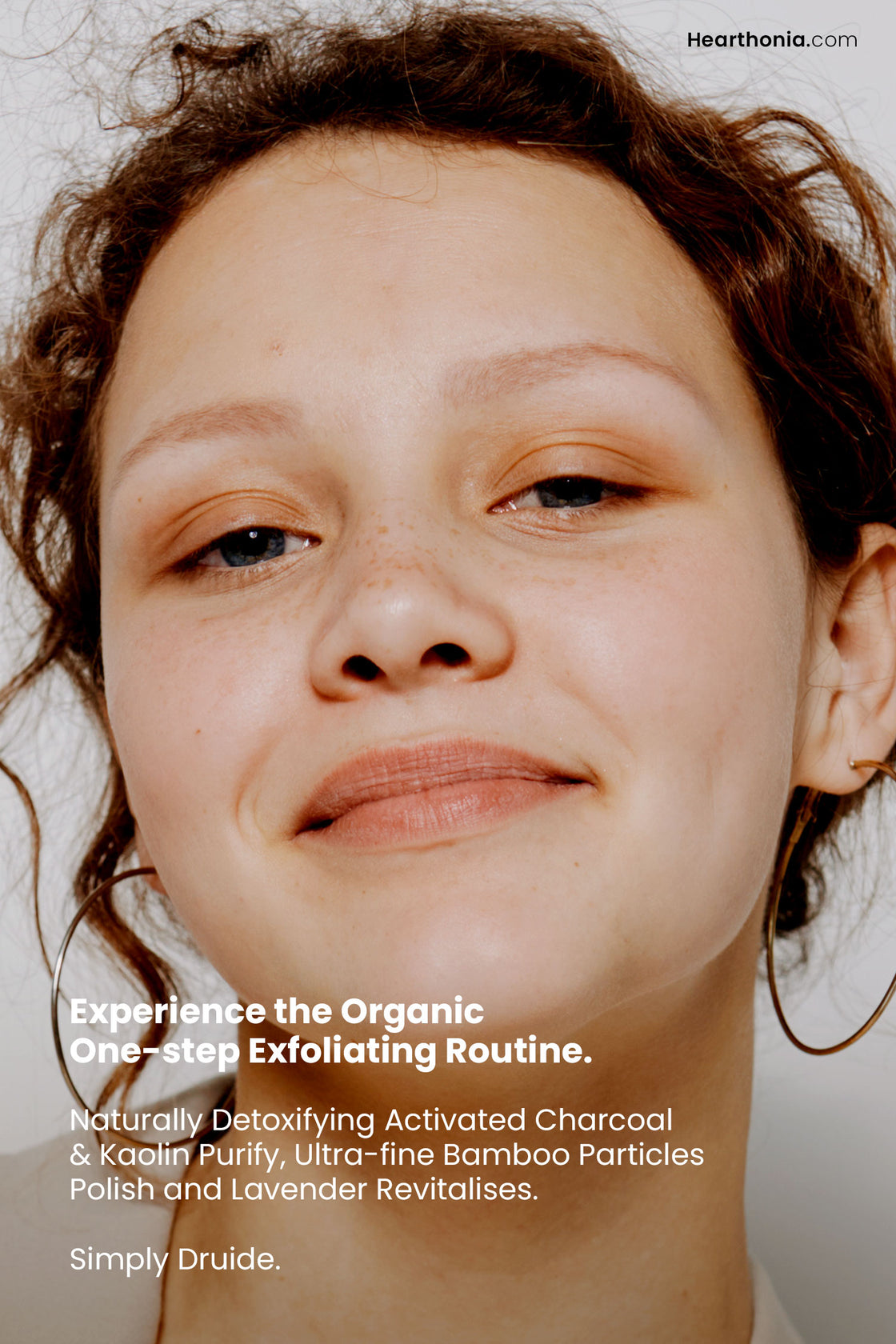 Smiling woman after facial exfoliation, with text stating naturally detoxifying activated charcoal and kaolin purify ultra fine bamboo particles polish and lavender revitalises".