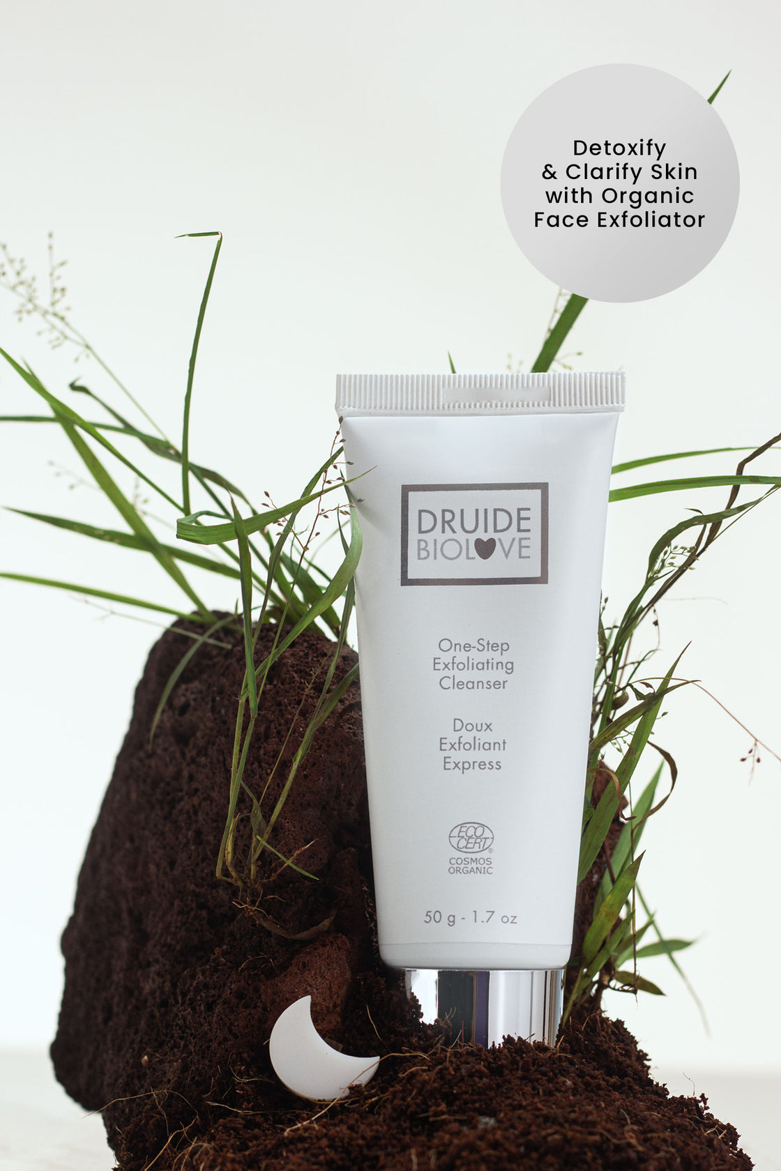 Druide Biolove Organic Exfoliating Cleanser for Sensitive Skin tube in natural environment of fresh soil and grass.