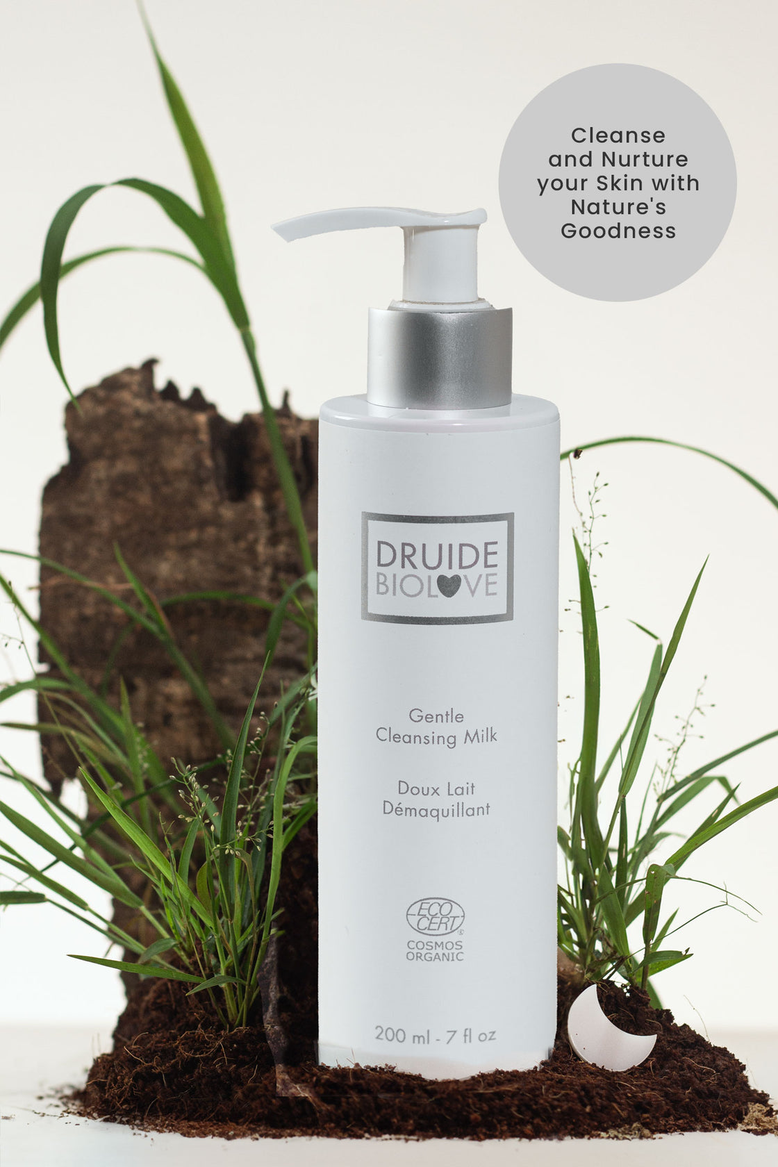Druide Biolove Organic Gentle Cleansing Milk dispenser shown on a mound of fresh soil with green grasses and text stating "cleanse and nurture your skin with nature's goodness".