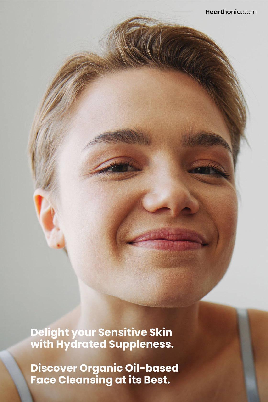 Short haired woman smiling with text stating "delight your sensitive skin with hydrating suppleness, discover organic oil-based face cleansing at its best".