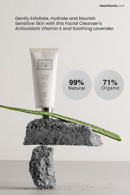 Druide Biolove Organic Exfoliating Cleanser in its white tube dispenser balances on two rocks, with text stating  99% natural and 71% organic ingredients.