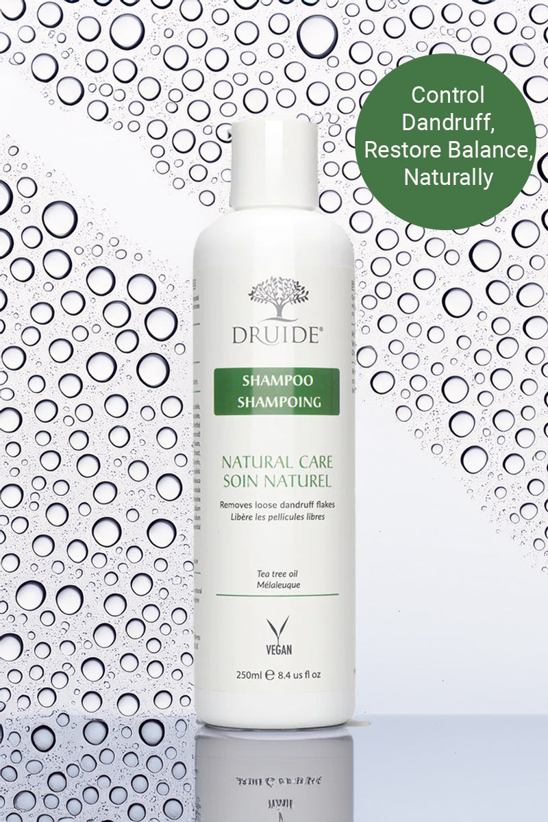 Druide Tea Tree Oil Shampoo dispenser shown against a background of water beads with text reading "control dandruff, restore balance, naturally".