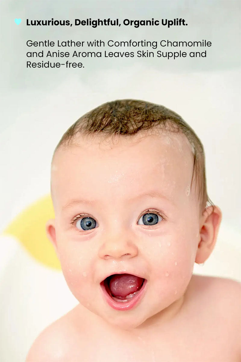 happy baby in awe after a bath with text reading "luxurious, delightful, organic uplift. gentle lather with comforting chamomile and anise aroma leaves skin supple and residue free".