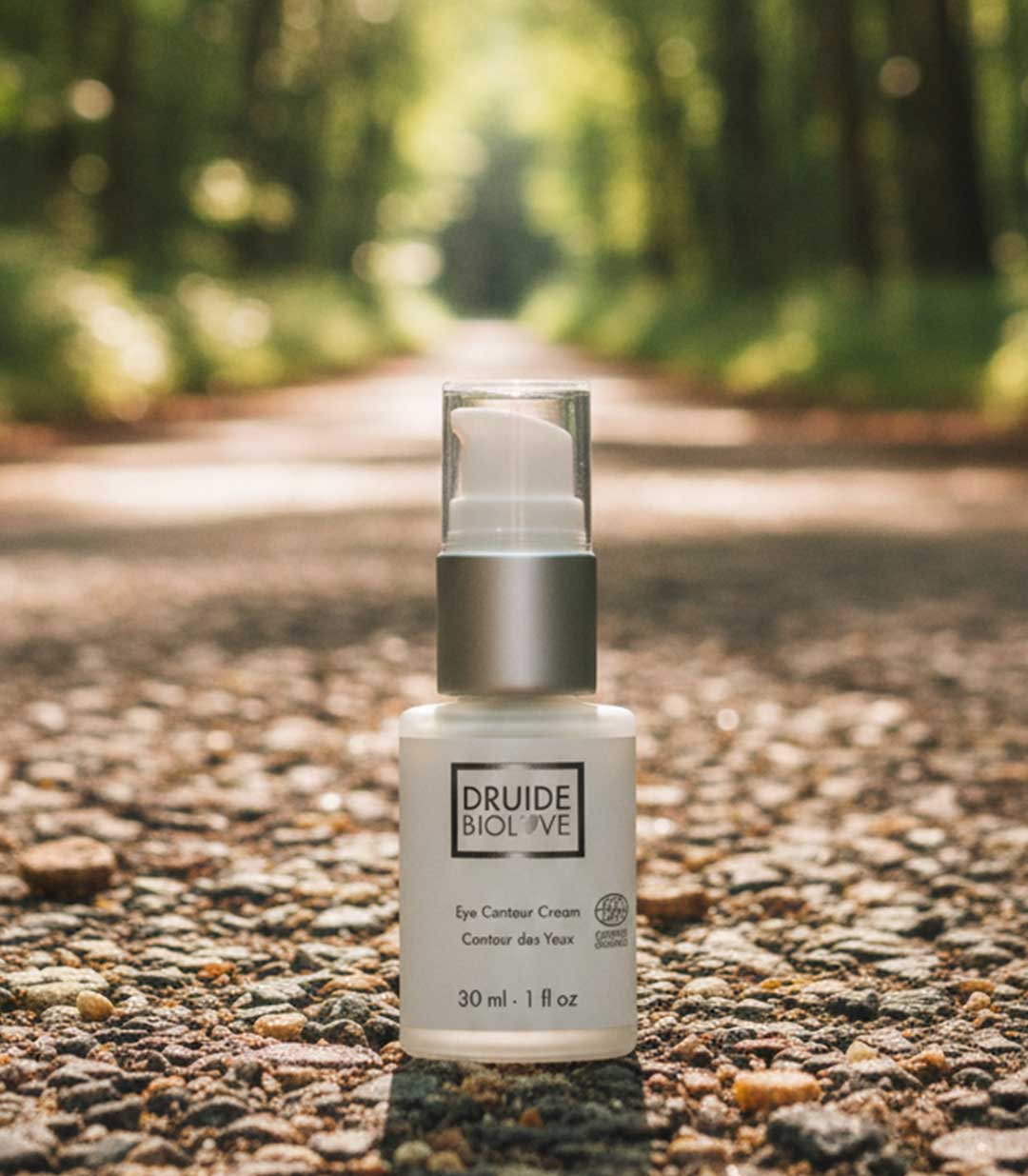 Druide Biolove eye contour cream bottle in UK country garden with blurred outdoor background.