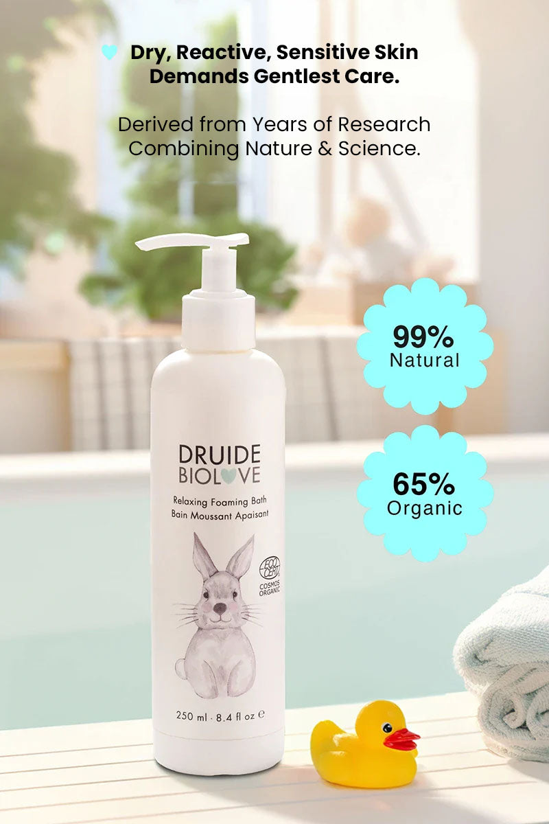 Druide Biolove Relaxing Foaming Baby Bubble Bath dispenser next to a bath tub with text reading "99% natural 65% organic, dry reactive sensitive skin demands gentlest care, derived from years of research combining nature and science".