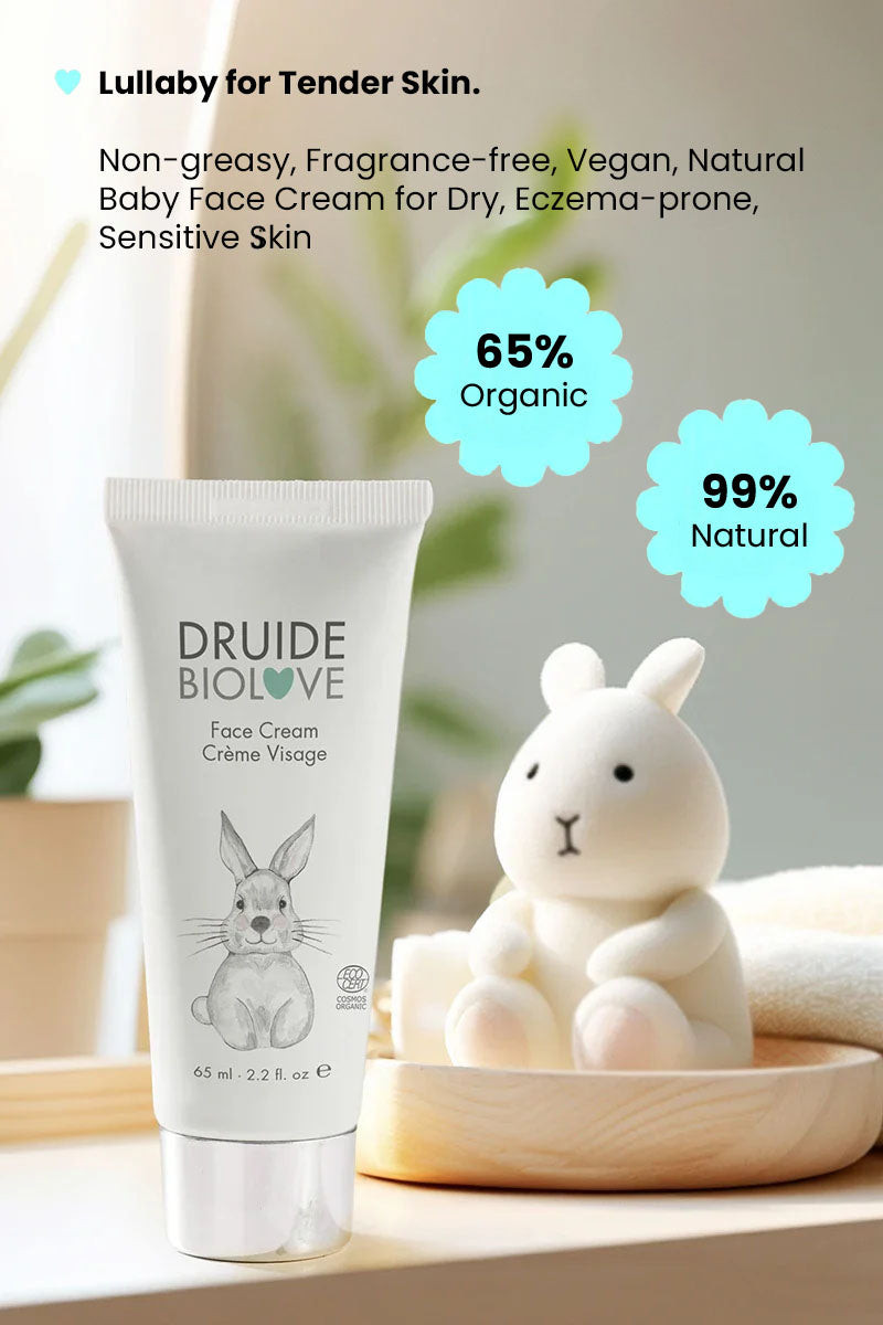 Druide Biolove organic baby face cream 
 sitting on a shelf with green plants and a teddy bear toy in background with text reading "99% natural, 65% organic, lullayby for tender skin. non greasy, fragrance free, vegan, natural baby face cream for dry eczema prone sensitive skin".