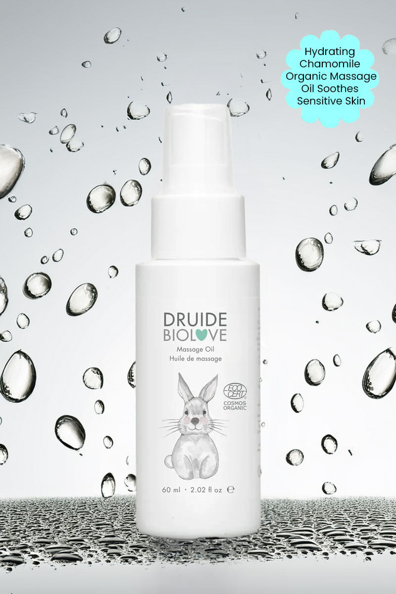 Druide Biolove organic massage oil against background if water beads with text "hydrating chamomile organic massage oil soothes sensitive skin".