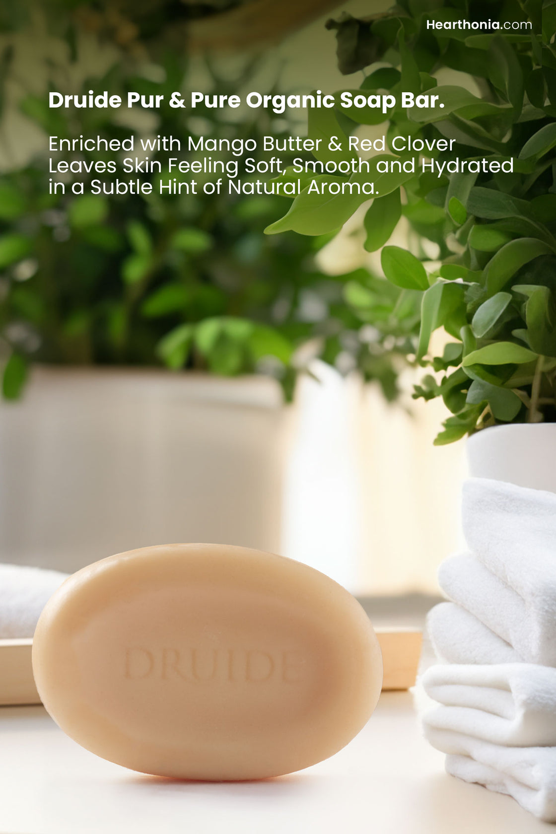 Druide Pur and Pure natural soap bar   
for Face & Body propped on a white surface next to a bathtub surrounded by green plants and bathed in natural sunlight with text reading "enriched with mango butter and red clover, it leaves skin feeling soft, smooth and hydrated in a hint of natural freshness".