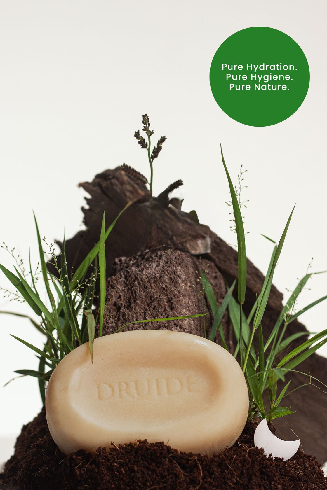 Druide Pur and Pure Natural Soap bar shown against a backdrop of fresh soil and grass with text reading "pure hydration, pure hygiene, pure nature".