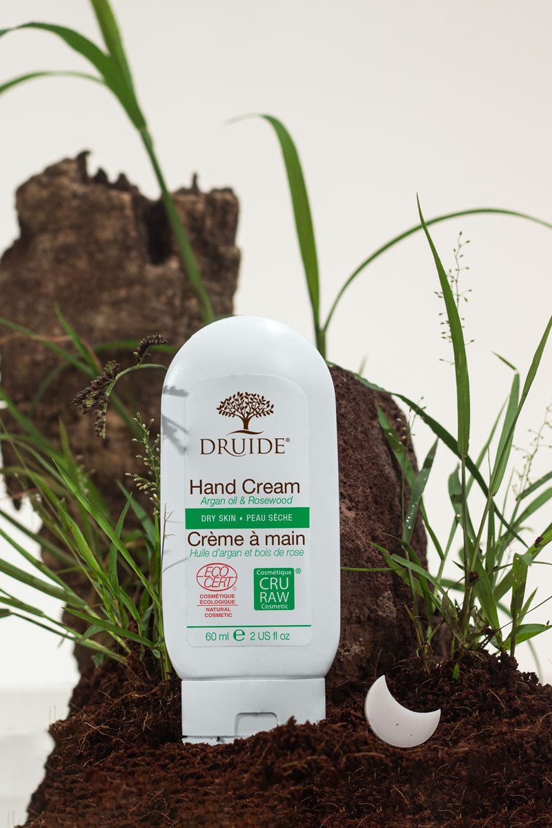 Druide organic Hand Cream for Dry Skin shown in a natural environment of fresh ground soil and grass.
